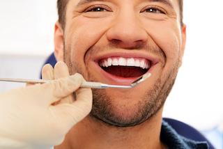 man smiling while getting dental check-up