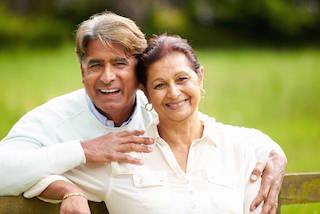 Man and woman smiling while sitting on bench