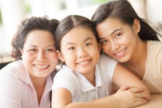 Grandma, mother, and daughter smiling 